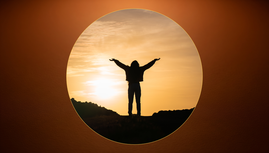 A person standing alone in stillness on a hill, soft light falling across their hands, the world around quietly present