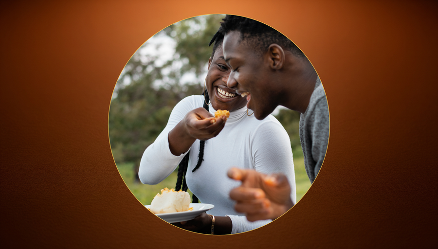 A group of people gathered around a shared table, hands feeding
