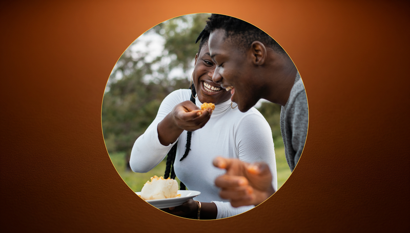 A group of people gathered around a shared table, hands feeding